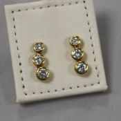 A pair of modern 18ct gold and three stone diamond drop earrings, 14mm.