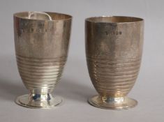 A stylish pair of George V ribbed silver beakers, on circular foot, Charles Boyton & Sons, London,