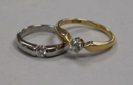 An 18ct gold and solitaire diamond ring and a similar white gold diamond ring.