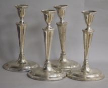 A set of four white metal oval candlesticks, (a.f.), 27cm. weighted.
