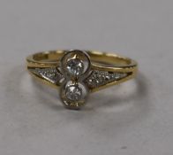 A 20th century 18ct gold and two stone diamond ring with diamond set shoulders, size K.