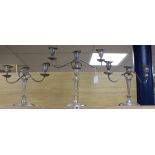 A suite of three silver plated two branch three light oval candelabra, comprising a pair and