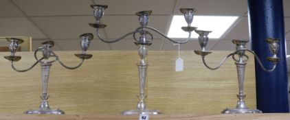 A suite of three silver plated two branch three light oval candelabra, comprising a pair and