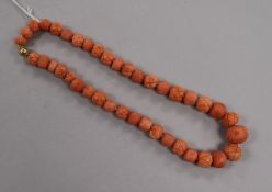 A single strand carved coral bead choker necklace with 18ct gold spherical clasp, 38cm.