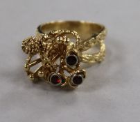 A 1970's? 14ct gold and garnet set rustic cocktail ring, size M.