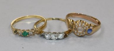 Three 18ct gold and gem set rings including three stone diamond and one lacking two stones.