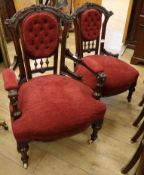 A pair of late Victorian walnut lady's and gentleman's armchairs, upholstered in buttoned red