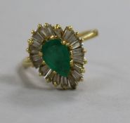 A modern 18ct gold pear shaped emerald and trapeze cut diamond set dress ring, size M.
