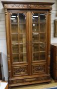 A 19th century French carved walnut Renaissance style two door barred glazed bookcase, H.220cm W.