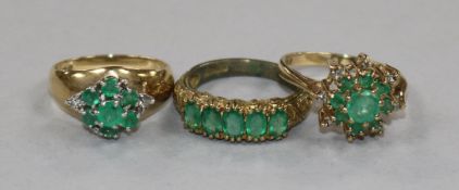 Two 9ct gold, emerald and diamond cluster dress rings and a 9ct gold and five stone emerald half
