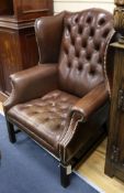 A leather button back wing armchair