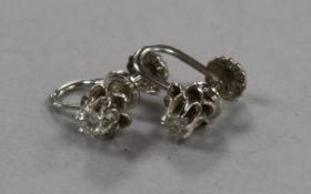 A pair of white metal and solitaire diamond ear clips.