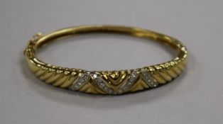 A modern 18ct gold and diamond set hinged bangle.