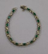 A modern 14ct gold, emerald and diamond set line bracelet, 17.5cm.