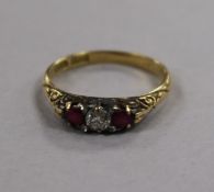 An early-mid 20th century 18ct gold ruby and diamond three stone ring, size P.