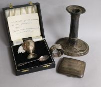 A silver egg cup and spoon, a cigarette case, a 19th century silver candlestick and a napkin ring.