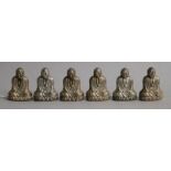 A set of six novelty sterling silver condiments, each modelled as a seated Buddha, one base missing,