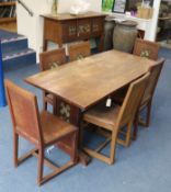 An Arts & Crafts style carved, decorated oak dining suite, comprising refectory table, six chairs