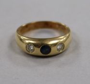 A 14ct gold and gypsy set three stone sapphire and diamond ring, size M.