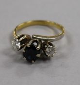 An 18ct gold and three stone sapphire and diamond ring, size N.