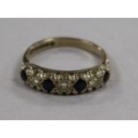 A 1970's 18ct gold and graduated seven stone sapphire and diamond half hoop ring, size N.