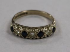 A 1970's 18ct gold and graduated seven stone sapphire and diamond half hoop ring, size N.