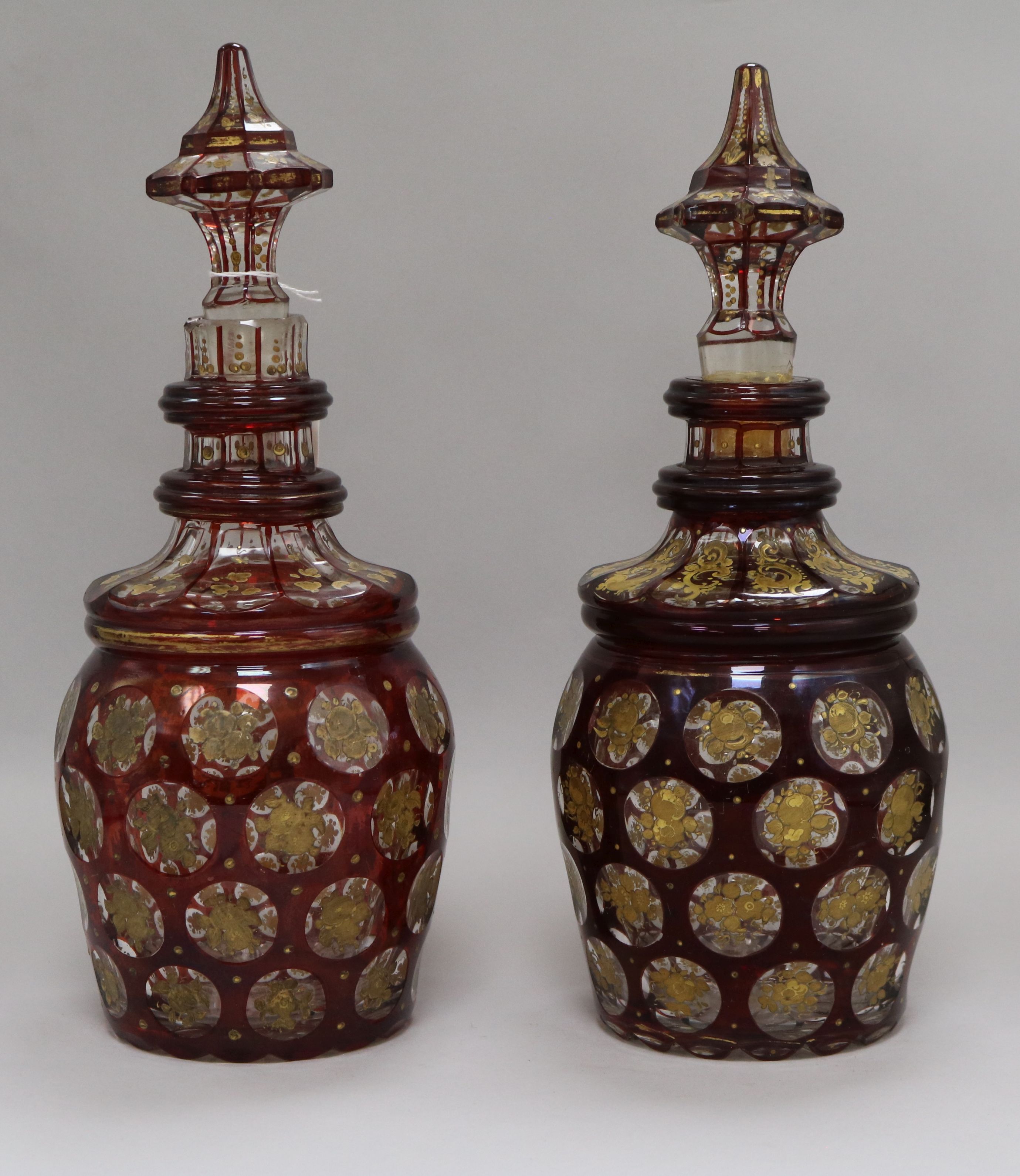 A pair of Bohemian gilt and ruby flash cut decanters with spear stoppers height 34cm