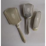 An Art Deco style silver mounted three piece mirror and brush set.