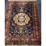 A large Persian black ground rug 170cm x 125cm