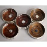 Two pairs of modern silver mounted wine coasters and a single silver mounted wine coaster.