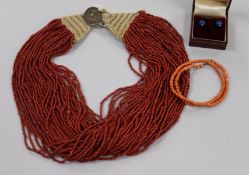 An Indian multi-strand coral bead necklace, one other coral bead necklace and a pair of ear studs.