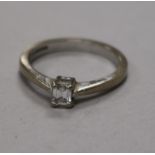 A modern 18ct white gold and solitaire emerald cut diamond ring, size M.