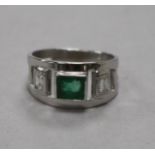 A modern 9ct white gold and emerald ring with diamond set shoulders, size K.