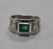 A modern 9ct white gold and emerald ring with diamond set shoulders, size K.