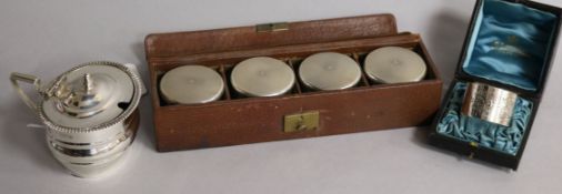 An Edwardian silver mustard, London, 1909, a cased set of four travelling silver mounted toilet jars