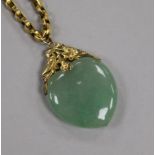 A yellow metal mounted heart shaped jade pendant, on a 9ct gold chain, pendant 39mm.