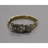 A yellow metal and three stone diamond ring, size Q.