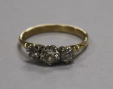 A yellow metal and three stone diamond ring, size Q.
