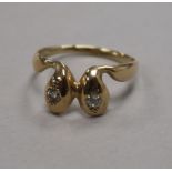 A yellow metal and diamond set twin serpent head ring, size S.