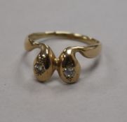 A yellow metal and diamond set twin serpent head ring, size S.