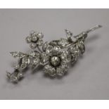 A white metal and diamond set floral spray brooch, size 7cm.