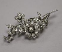 A white metal and diamond set floral spray brooch, size 7cm.