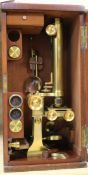 A late 19th century lacquered brass binocular microscope by Cary, 181 Strand, London, in fitted