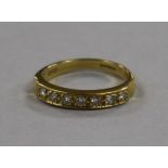 An 18ct gold and seven stone diamond half eternity ring, size R.