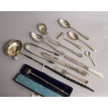 A George III silver caddy spoons and a small group of silver flatware including Victorian pickle