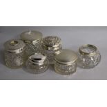 Six assorted silver mounted toilet jars.