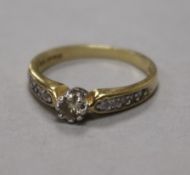 An 18ct gold and single stone diamond ring, with diamond set shoulders, size R.