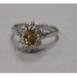 An early 1970's 18ct white gold , yellow topaz and diamond oval cluster ring, size M.