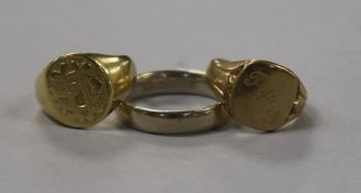 An 18ct gold signet ring, a 9ct gold signet ring and an 18ct gold white gold wedding ring.