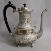 An Indian embossed white metal coffee pot, stamped "Sterling Silver", gross 35.5 oz.